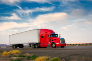 Red truck moving on a vibrant highway